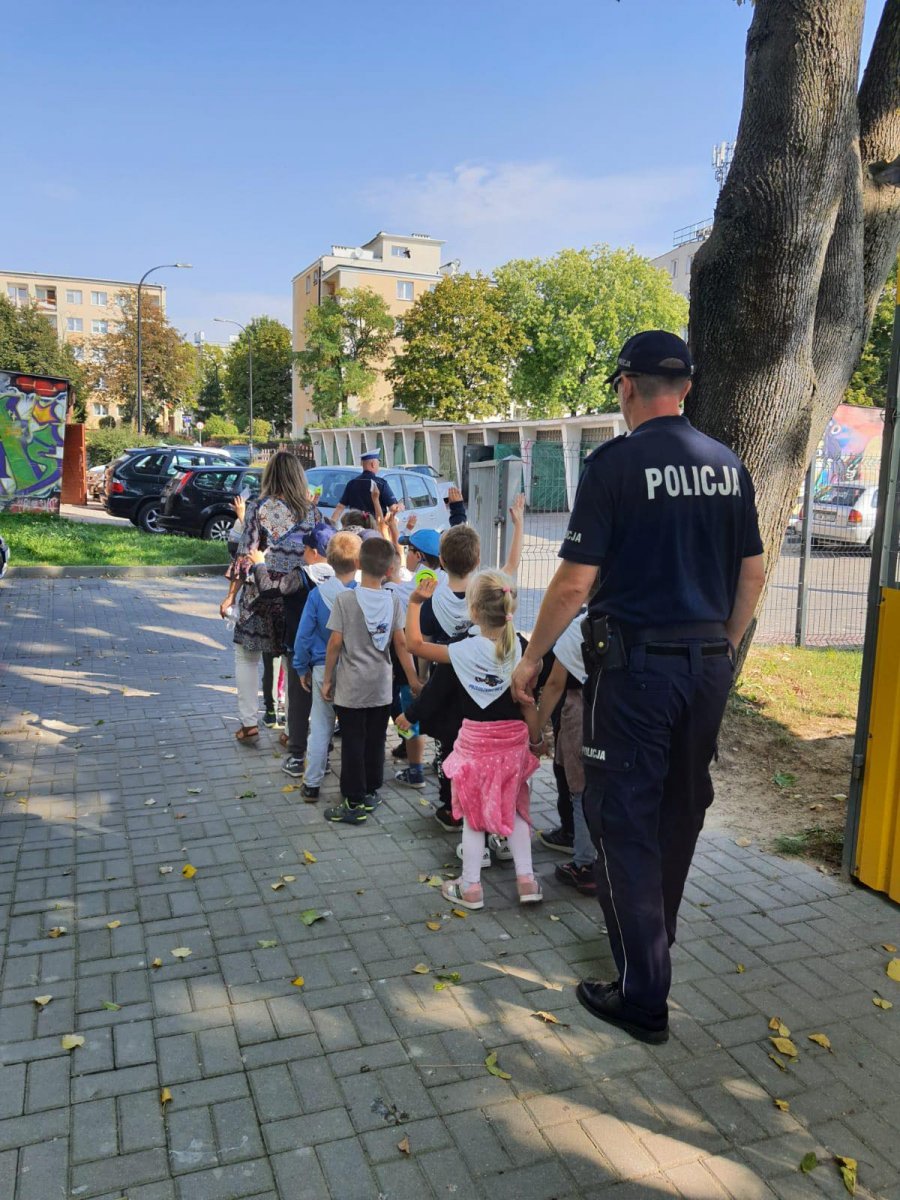 dzieci idące chodnikiem z policjantami